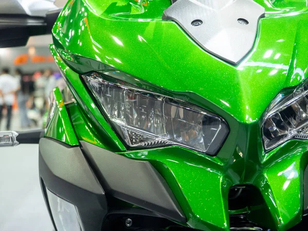 Closeup front light of motorcycle sport green color