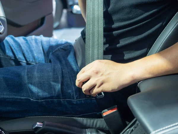 Man hand wearing sti belt in the new car