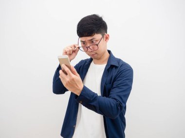 Asyalı adam elindeki cep telefonuna baktı diye gözlüklerini çıkardı. Beyaz arka planda şüphe ve şok olmuş bir ifade vardı.