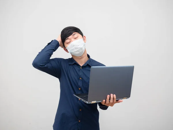白い背景に手でラップトップを保持マスク感頭痛を身に着けている病気の男 — ストック写真