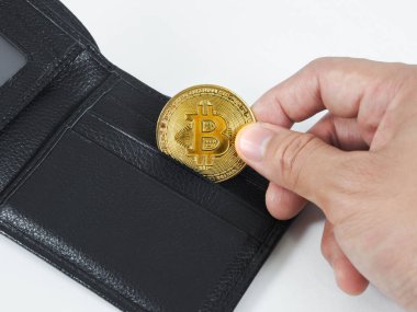 Closeup hand pick up golden bitcoin at wallet white background