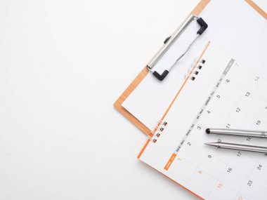 Takvim üzerindeki kalemi masadaki belge panosuyla birlikte kapalı tut