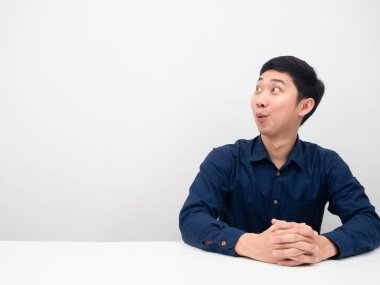 Genç adam oturuyor ve beyaz arka plan fotokopisine bakarken şaşkına dönüyor.