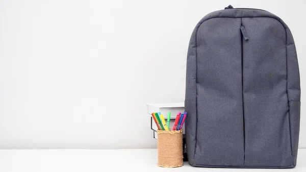 School bag with pencil box and books on the desk white background copy space