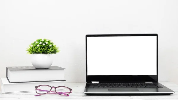 笔记本电脑白色屏幕 装有眼镜和书籍 放在家里的办公桌上 — 图库照片