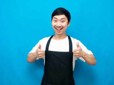 Önlük takan neşeli adam başparmağını kaldırıyor, gülümsüyor, mavi arka plan