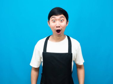 Önlük takan Asyalı adam, mavi arka planda inanılmaz bir duygu hissediyor.