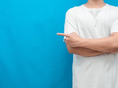 Man gesture point finger at copy space blue background
