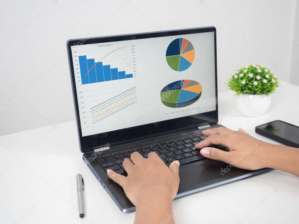 Close up hand using laptop charts graphs business at screen on the table copy space
