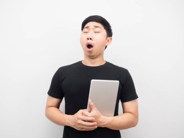 Asyalı bir adam elinde hapla uykulu ve esniyor.