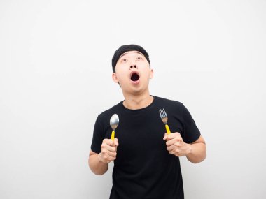 Elinde çatal bıçak olan Asyalı adam fotokopi alanının üstüne bakarken heyecanlanıyor.