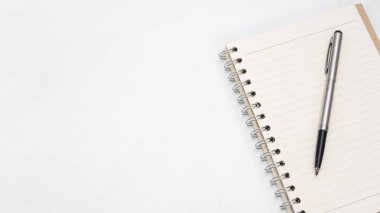 Silver pen and notebook blank page on the table top view copy space