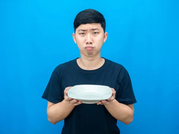 Hungry Man Holding Empty Dish Gesture Want Food Blue Background — Fotografia de Stock