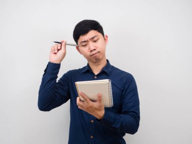 Elinde kalem tutan ve elinde boş bir defter olan bir adam bir şey düşünüyor.