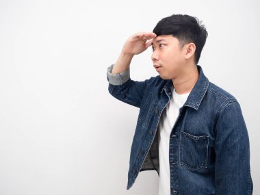 Yan görünüm Asyalı erkek kot gömleği baktığı için el hareketi yapıyor.