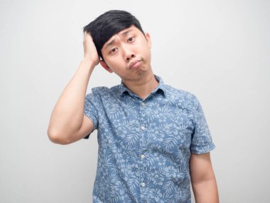 Mavi gömlekli adam, kafası karışık hareket ediyor, başını soyutluyor.