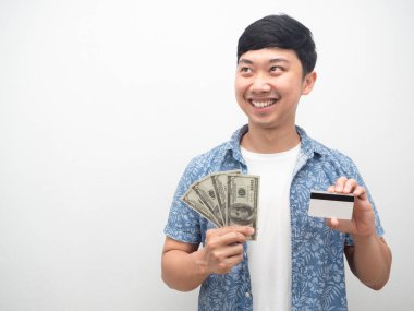 Asyalı adam kredi kartı ve para tutuyor mutlu bir gülümseme fotokopi alanına bakıyor