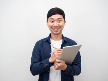 İş adamı neşeli bir şekilde elinde tablet ve kalemle gülümsüyor.