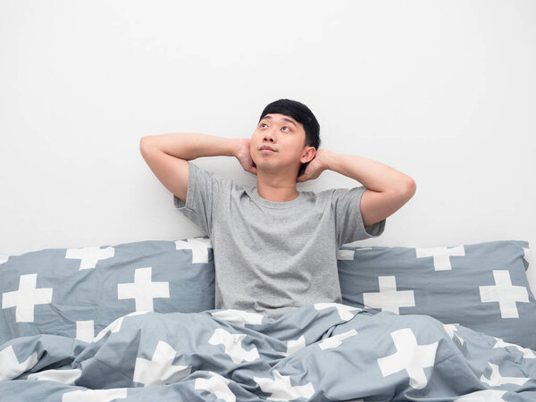 Asian man sitting on the bed gesture relax and thinking about something