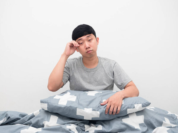 Man sitting on the bed with pillow gesture sleepy