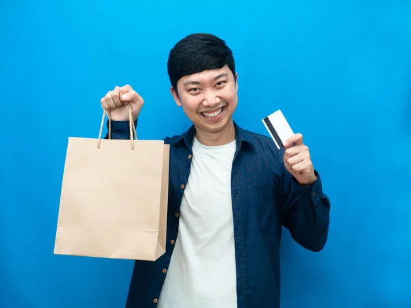 Izolovaný Muž Ukazuje Papírové Tašky Kreditní Karty Modré Pozadí Nákupní — Stock fotografie