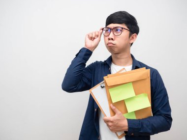 İşçi genç adam bardakları taşıyor. Elinde çok fazla iş kağıdı var. Yüzünde fotokopi alanına bakarken endişe duyuyor.