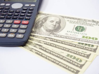 Close up calculator with a lot of money on workplace isolated