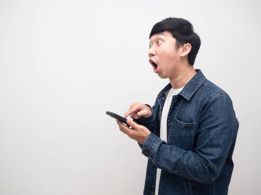 Akıllı telefon kullanan Asyalı erkek kot pantolonu fotokopi odasına bakarken şok oluyor.