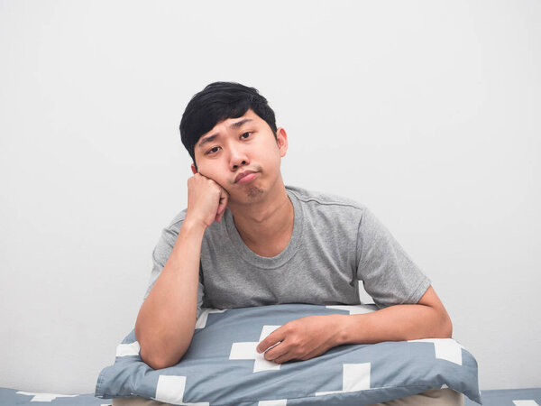 Young man wake up at morning on the bed feel bored to work