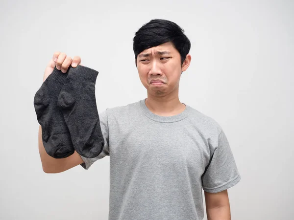 Asian man holding dirty socks feels smelly portrait