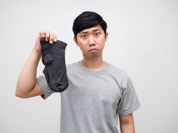 Young man holding dirty socks isolated