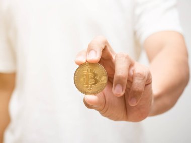 Yakın plan adamı elinde altın Bitcoin dijital para tutuyor.