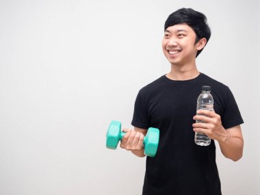 Genç adam, sağlıklı gülümse. Dambılı su şişesiyle izole et.