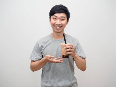 Genç adam elinde köpüklü çay tatlı, mutlu bir gülümseme.