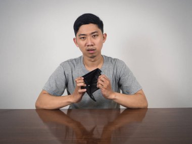 Asyalı adam cüzdanını aç. Para yok, zavallı adam konsepti.