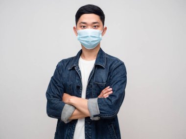 Yakışıklı Asyalı erkek gömleği. Tıbbi maske takıyor. Kolları çapraz.