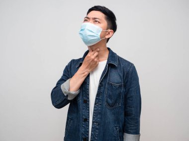 Pozitif erkek gömleği, tıbbi maske takıyor. Boynuna dokununca boğazı ağrıyor.