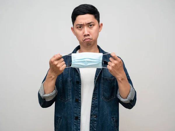 Asian man jeans shirt serious emotion take off his medical mask isolated