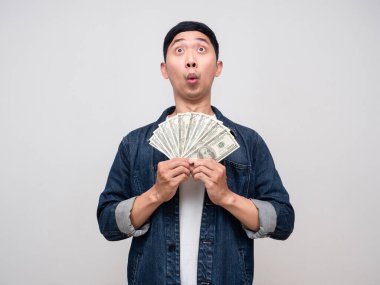 Positive man jeans shirt earn money in hand feels excited looking above isolated