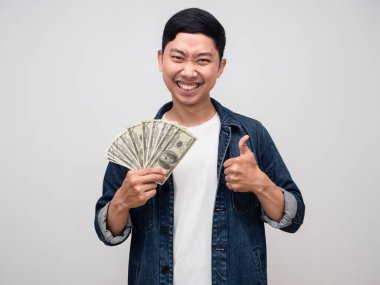Cheerful asian man jeans shirt gentle smile earn money in hand and thumb up isolated