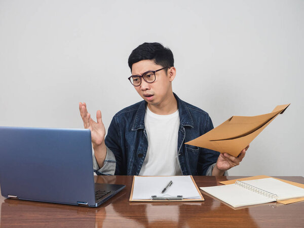 Male employee wear glasses work hard and very busy at working table feels tried