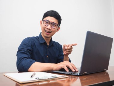 Businessman at workplace table point finger at laptop