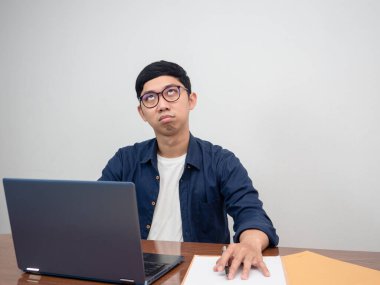 Asian man wear glasses sitting at working table feels bored about work