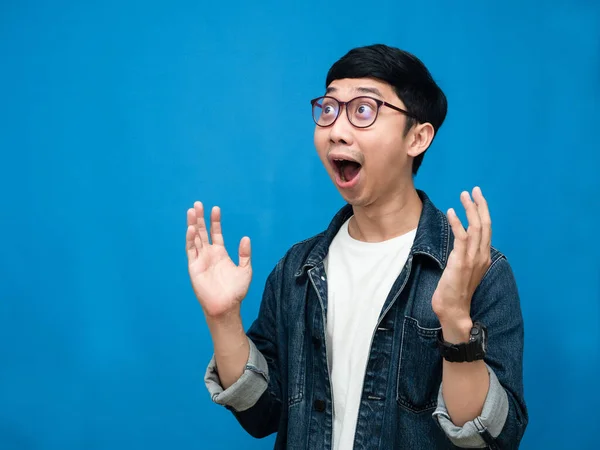 Asian man wear glasses jeans shirt gesture amazed blue background