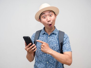 Tourism man with backpack point finger at mobile phone feels amazed with holiday