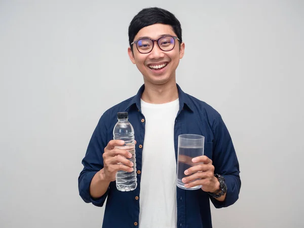 Asian man wear glasses happy smile hold water bottle with a glass of water isolated