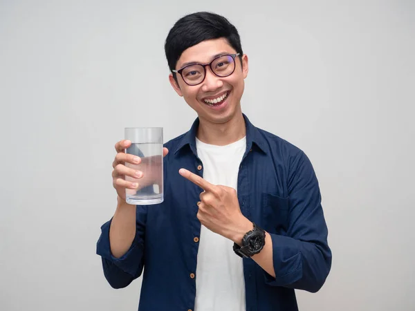 Young businessman wear glasses smiling point finger at glass of water isolated