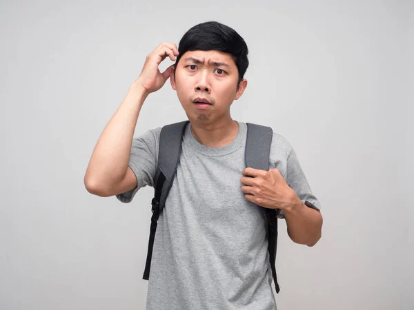 Asian man with backpack scratch head feels confused isolated