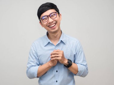 Neşeli adam gözlük takar gülümser ve utangaç jest yapar.