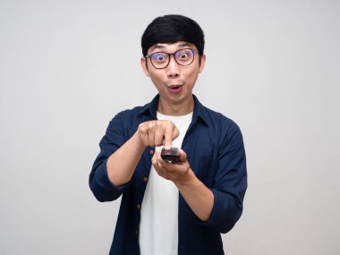 Genç Asyalı adam uzaktan kumandalı televizyon karşısında heyecanlanıyor.